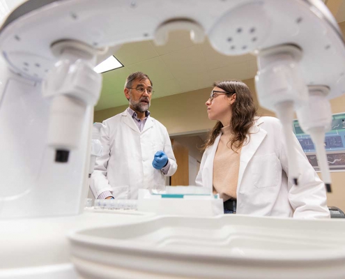 Researchers have a conversation in a laboratory.